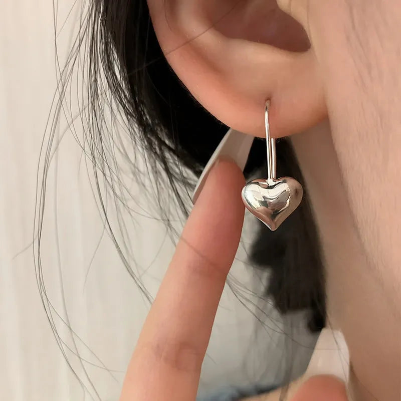 Silver-coloured heart-shaped earrings with three-dimensional design and glossy Korean style