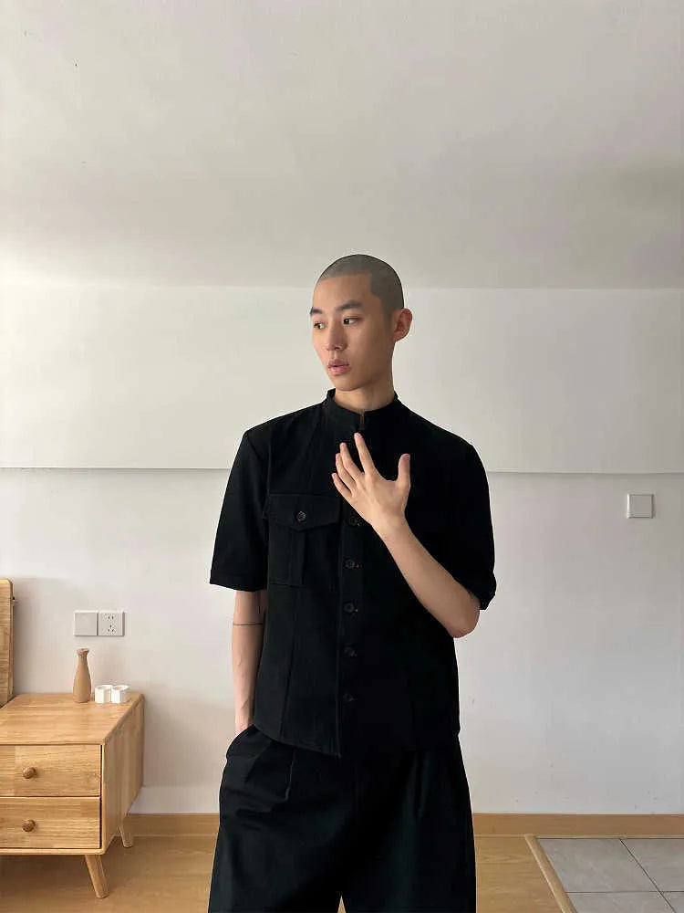 Black handmade loose fit half sleeve hunting shirt with a traditional shirt collar on a hanger.