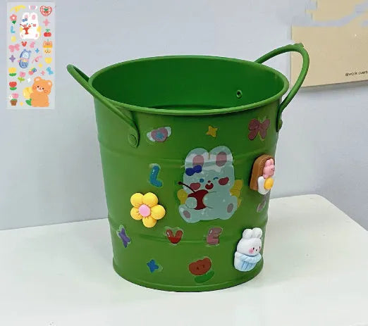 Round metal pen holder in green colour with decorative sticker patch design on desktop