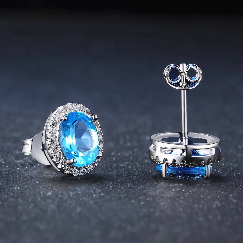 Geometric blue topaz and sterling silver four-piece jewellery set with earrings, ring, pendant, and necklace.