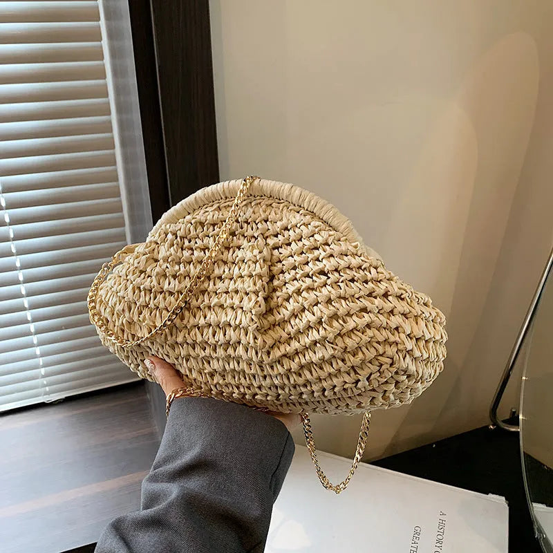 Women's straw beach bag with chain trim in khaki colour, showing shell shape and shoulder strap