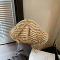 Women's straw beach bag with chain trim in khaki colour, showing shell shape and shoulder strap