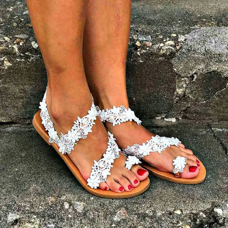 White women's flat sandals with rhinestone flower decoration and patent leather finish