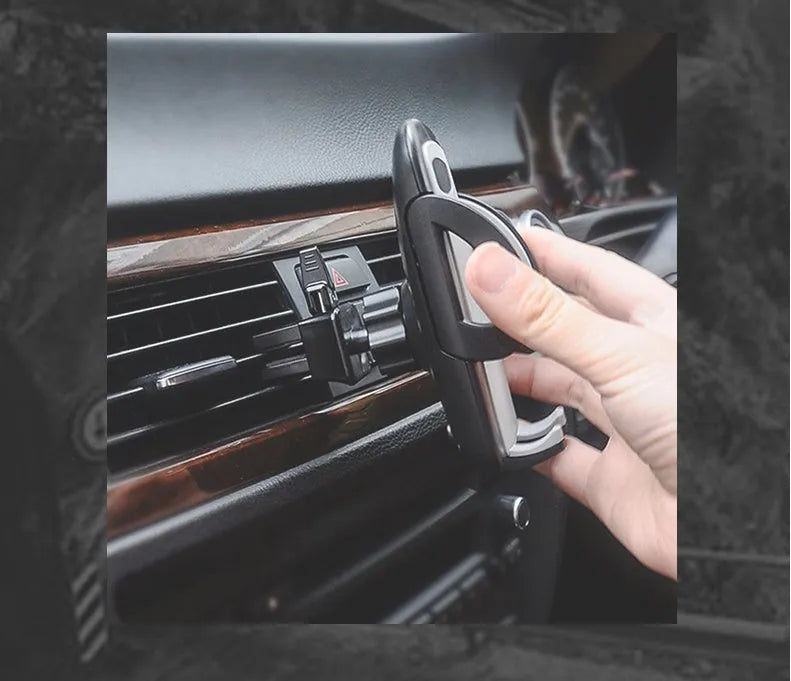Black universal car air vent mobile phone holder mounted on a car vent, holding a smartphone.