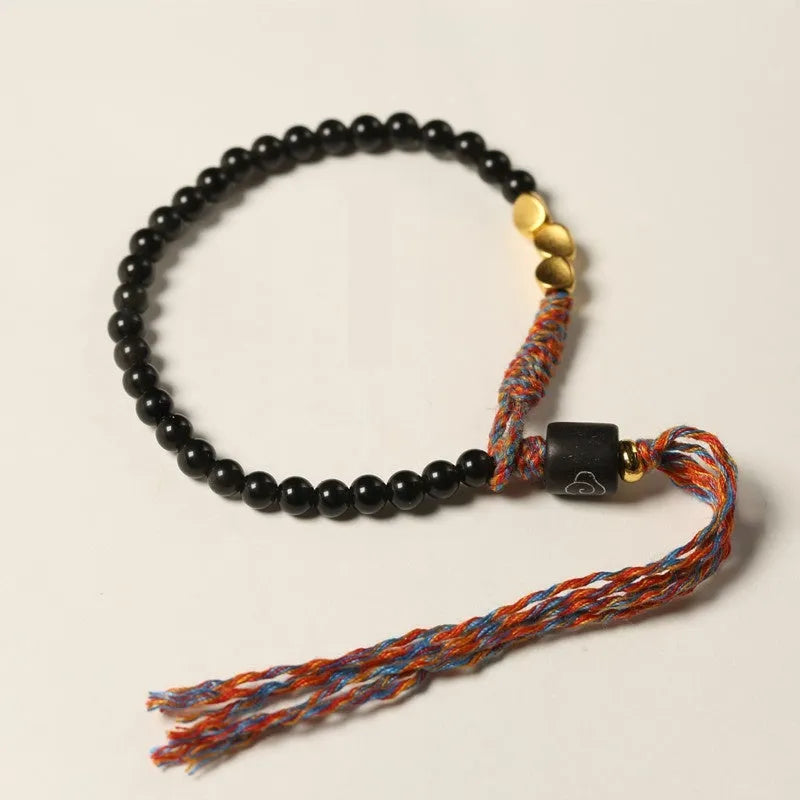 Hand-woven obsidian carrying strap bracelet with a stone bead, showing its 4mm width and adjustable length.