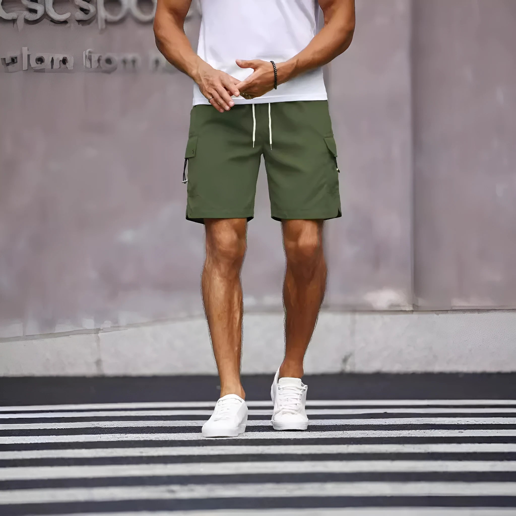 Man wearing loose fit army green straight leg workwear shorts made from cool silk cotton fabric.