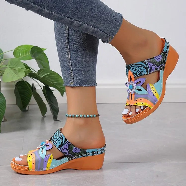 Coloured ethnic flat sandals with a slope heel and totem design on a cowhide upper.