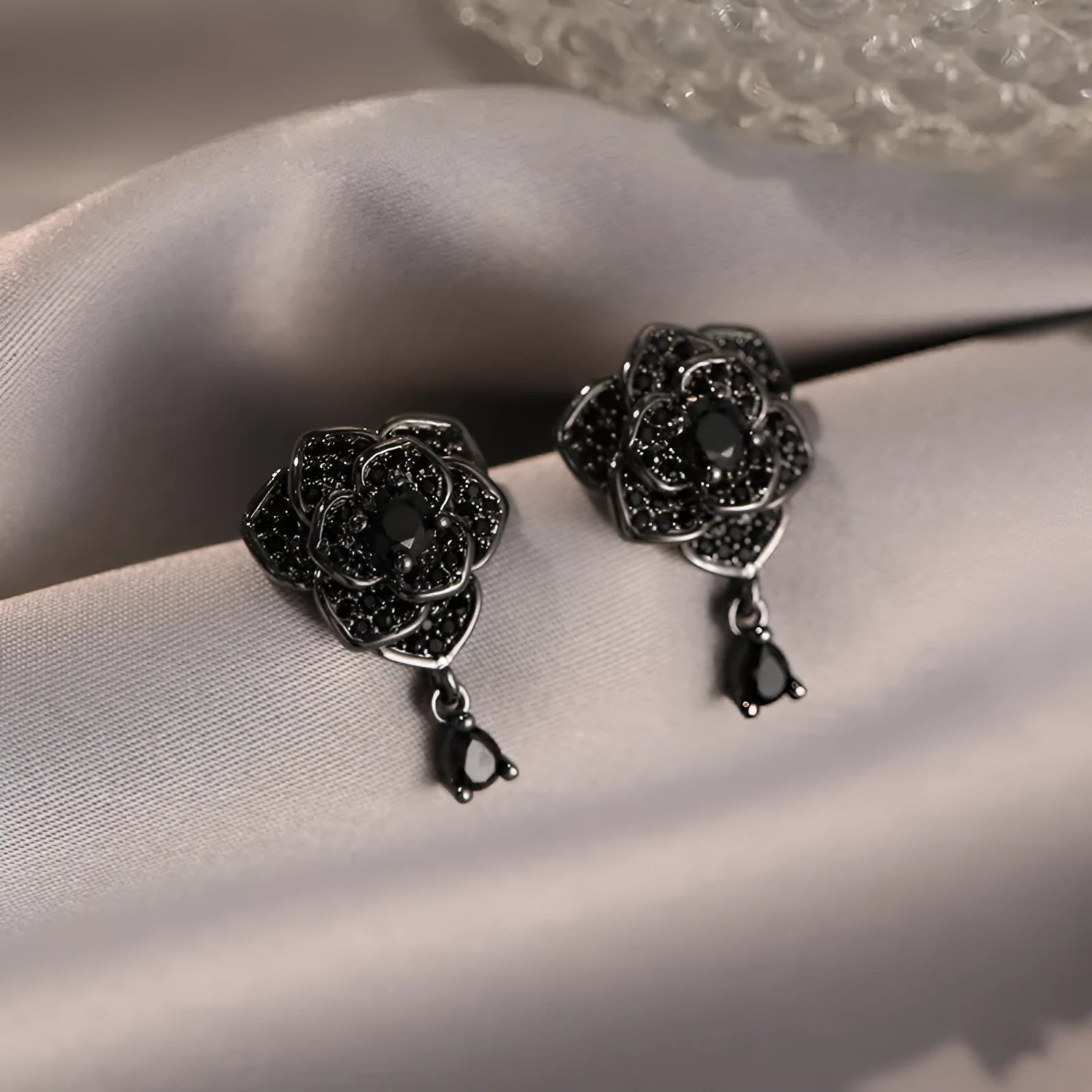 Pair of black rose zircon floral stud earrings with an 18K gold electroplated finish on copper.