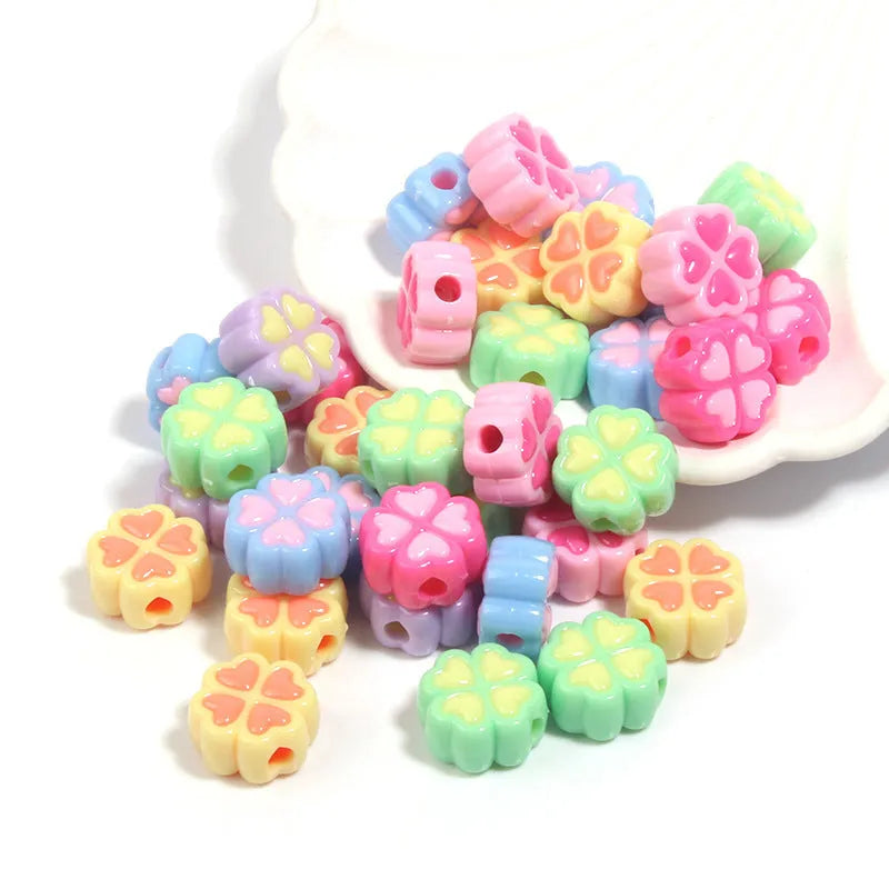 Assortment of frosted acrylic four-leaf clover shaped beads in rose red, pink, yellow, green, blue, and purple colours.