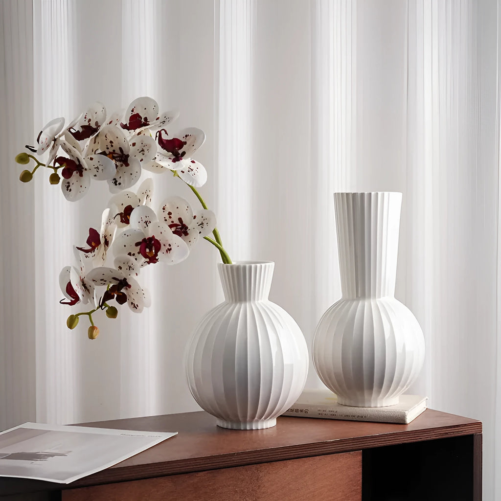 White ceramic ball vase with blue stripes on wooden table