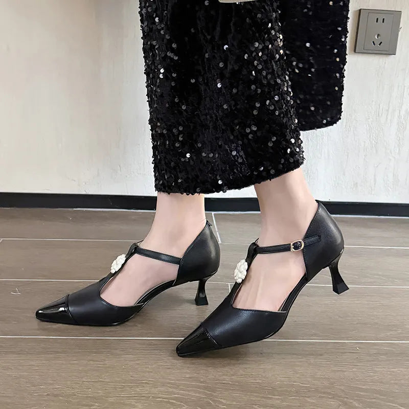 Women's black floral stiletto heel shoe with pointed toe and buckle detail on a beef tendon sole.