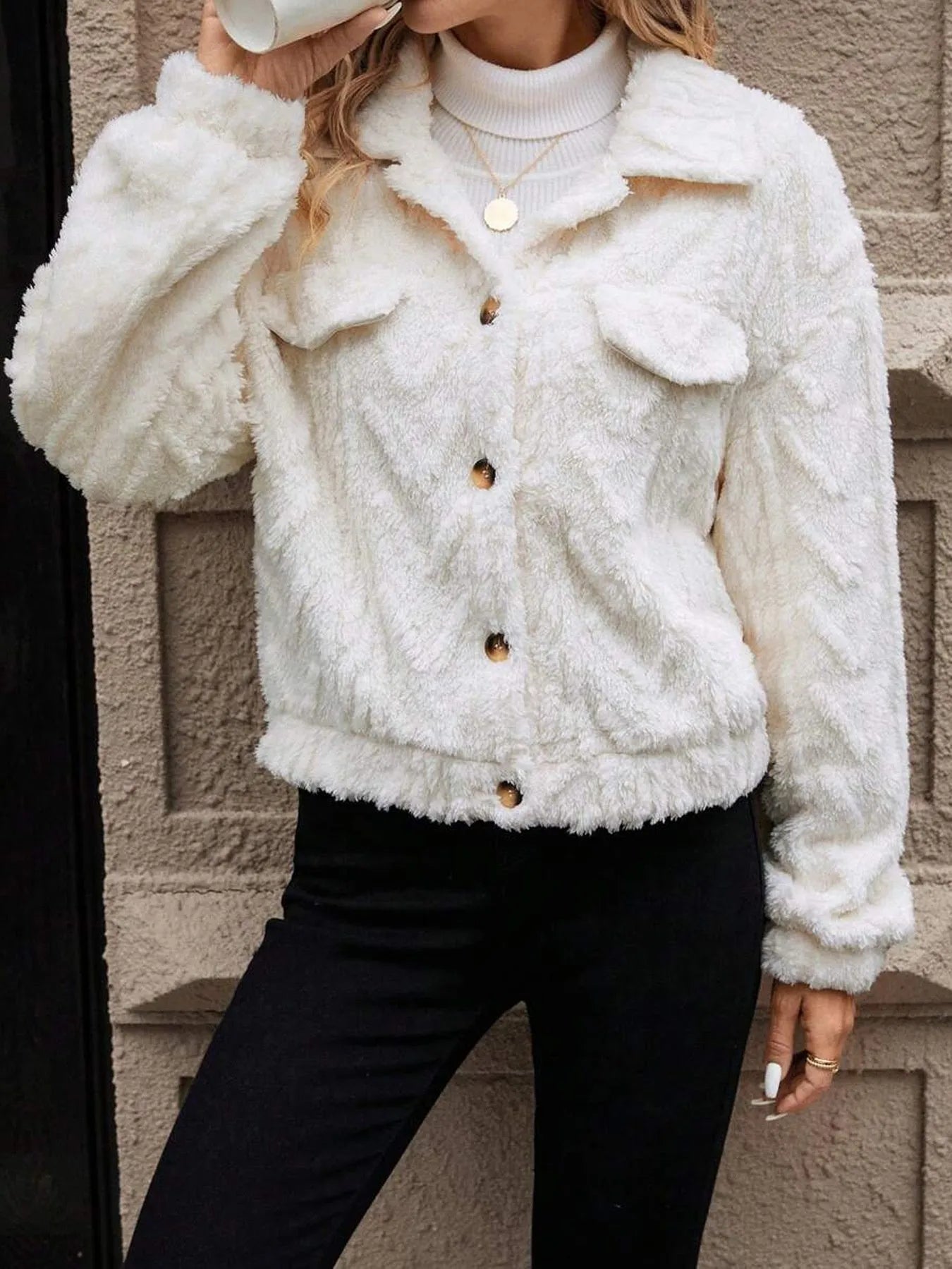 Ivory white women's cardigan coat with buttons and plush fabric on a hanger.