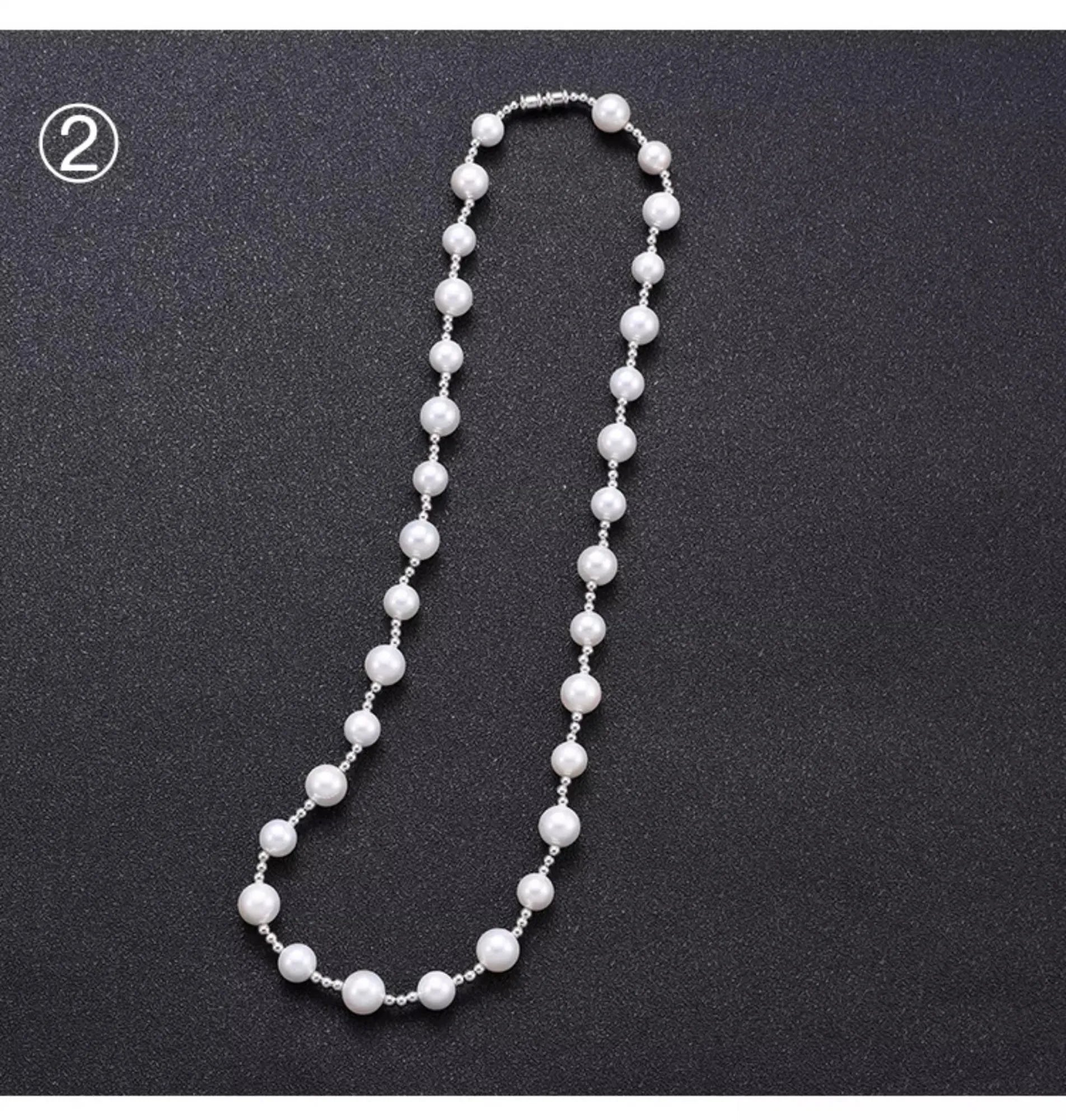 White freshwater pearl necklace with round bead chain and sterling silver platinum beads on a neutral background