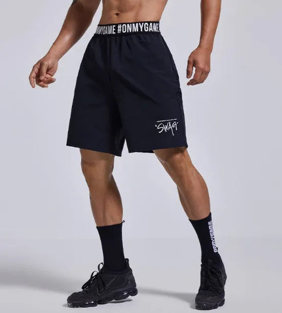 Men's loose black sports shorts with elastic waist and letters detail, laid flat.