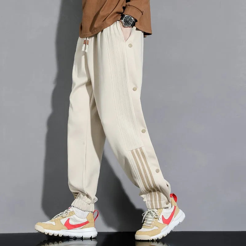 Man wearing loose grey sweatpants with ankle ties and a high waist.