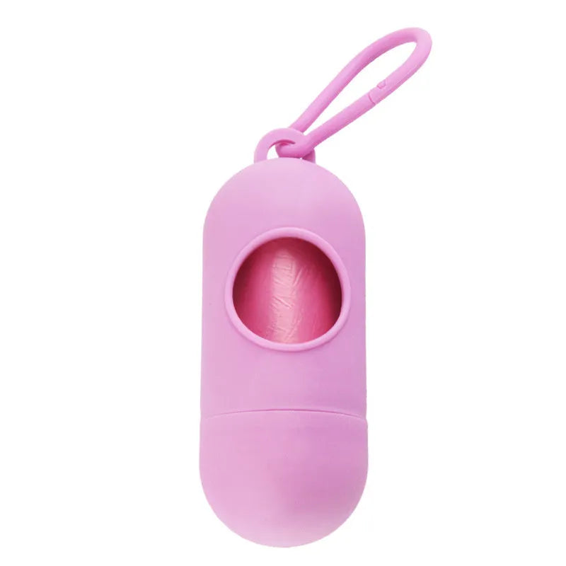 A compact black dog poop bag holder with a side hook and Velcro strap, shown next to a roll of waste bags.