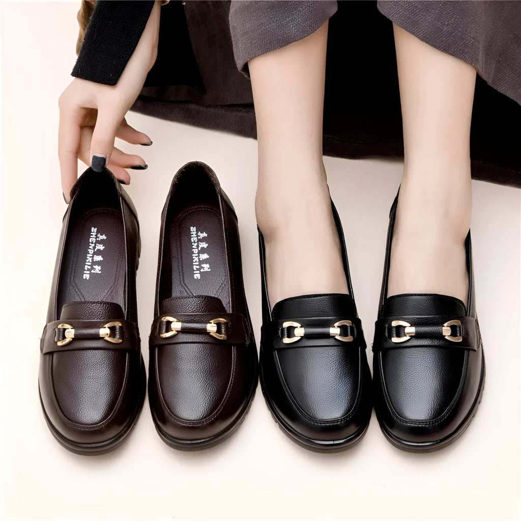 Black soft leather pumps with a round toe, low flat heel, and shallow cut design on a plain background.