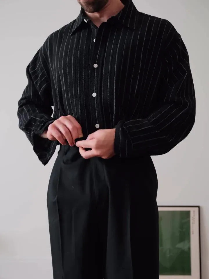 Black and white pinstriped men's long sleeve button-down shirt on a hanger.