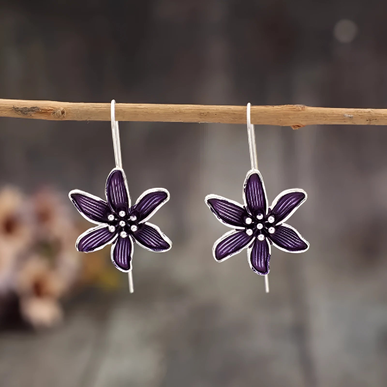 A pair of purple flower-shaped alloy earrings with an electroplated finish.