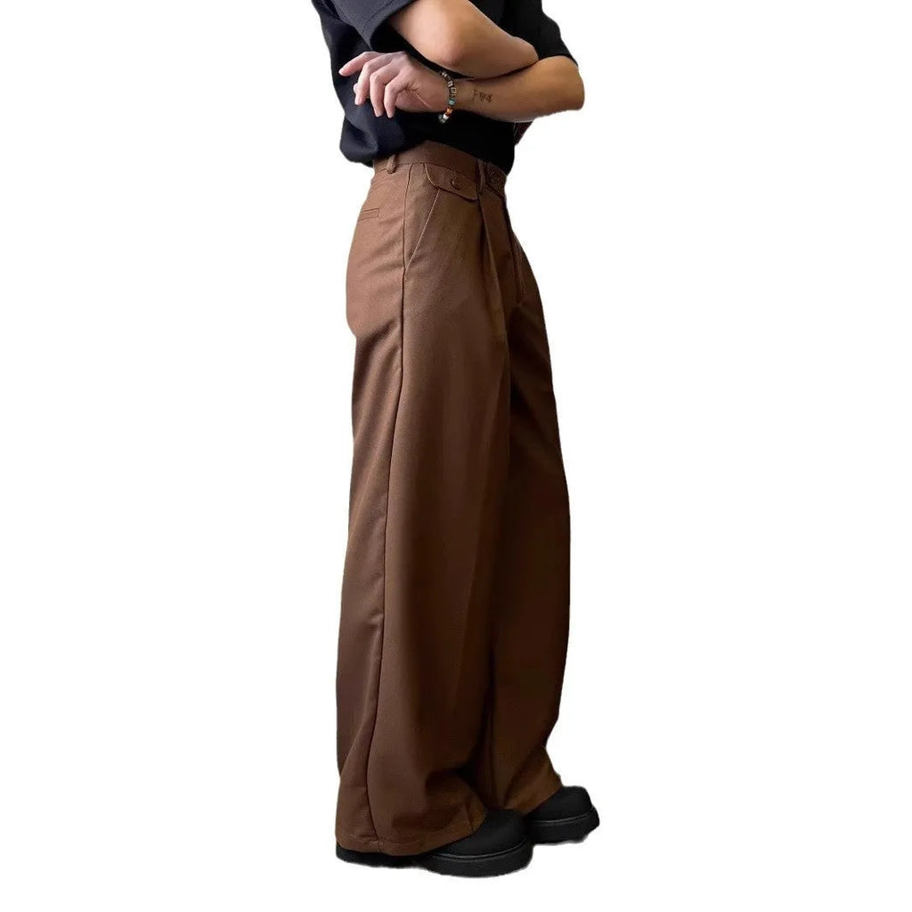 Men's brown straight-leg wide-drape trousers on a hanger, showing loose fit.