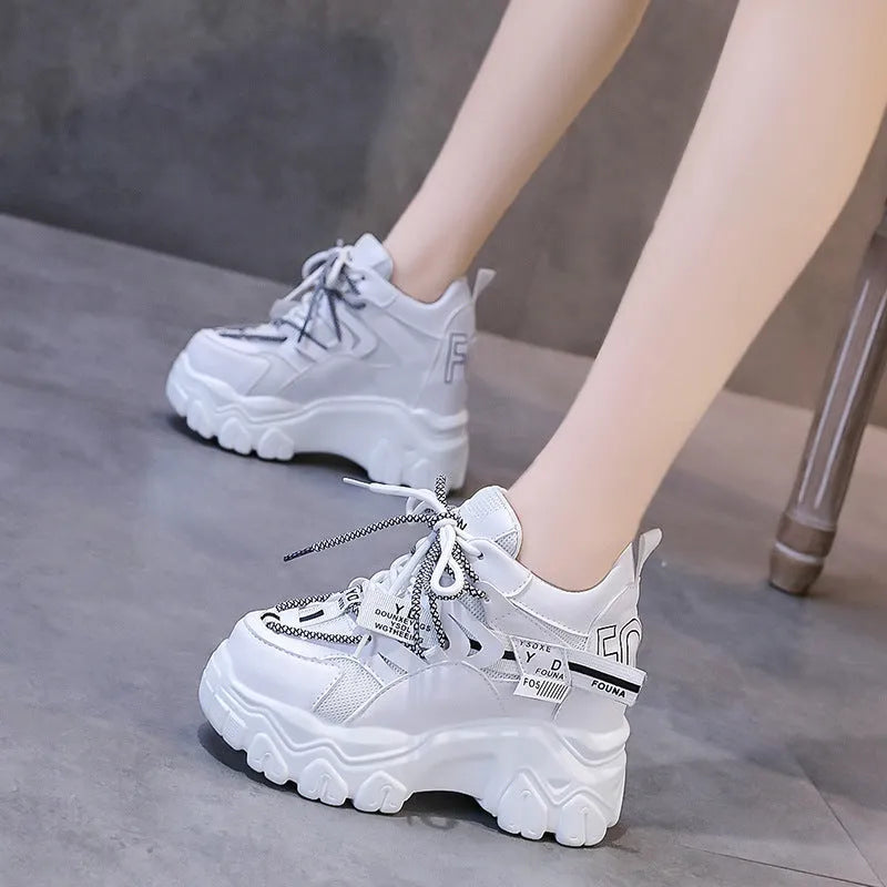 Women's white mesh platform sports shoes with cross strap and a high rubber sole.