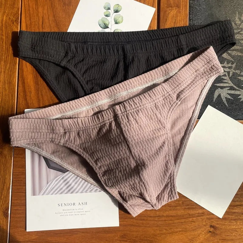 Men's solid colour cotton triangle briefs in apricot, shown from the front on a mid-waist fit model.