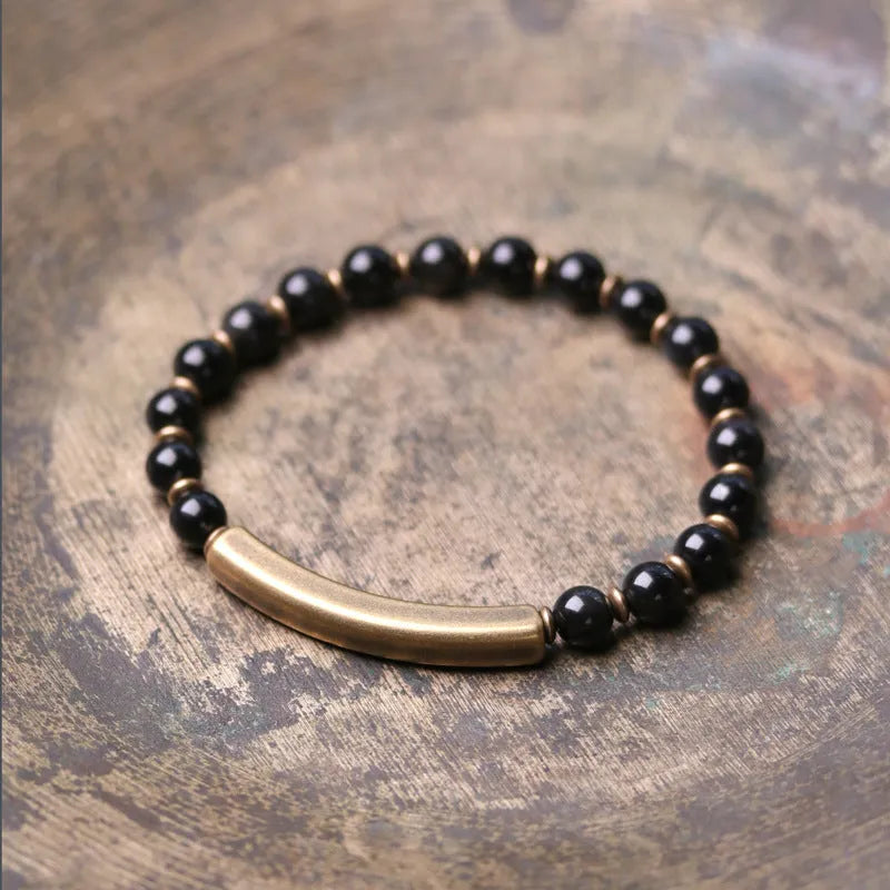 Layered retro ethnic bracelet for men and women with stone beads and brass accents on a wrist.