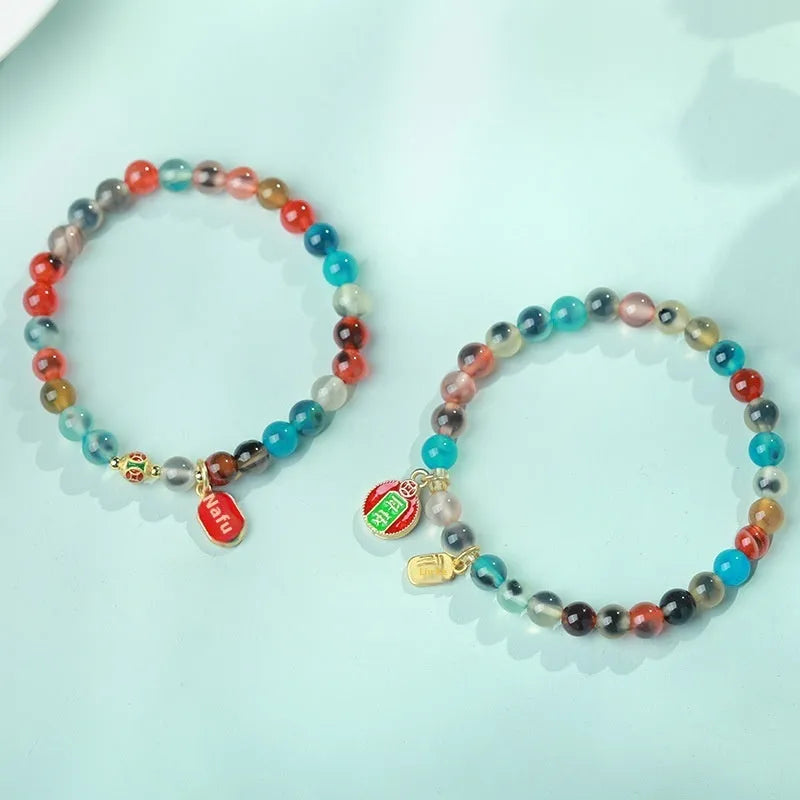 Handmade women's agate bracelet with coloured glaze copper coins in a snake chain, showing fu character or swallowing gold beast motifs.