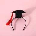 Small pet wearing a woolen felt doctor's degree hair band with a red cap bow tie attached