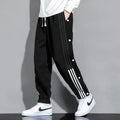 Man wearing loose grey sweatpants with ankle ties and a high waist.