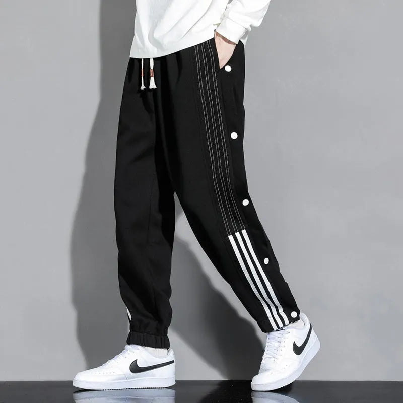 Man wearing loose grey sweatpants with ankle ties and a high waist.