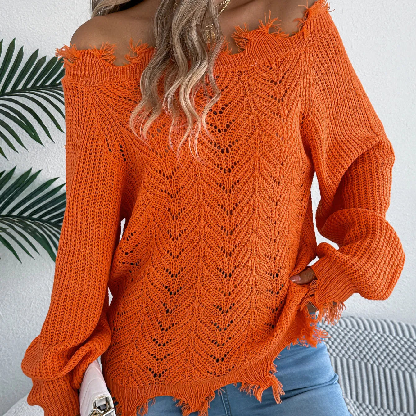 White women's hollow-out knit sweater with an off-the-shoulder neckline and long sleeves.