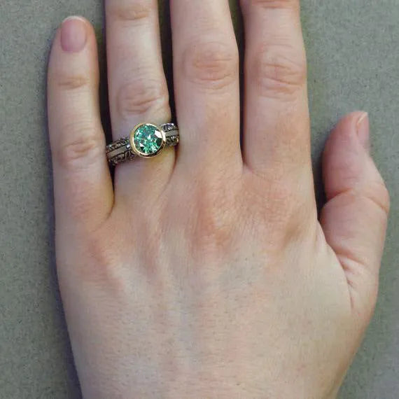 Green silver gold-plated flower-shaped vintage ring with colour separation design on a neutral background
