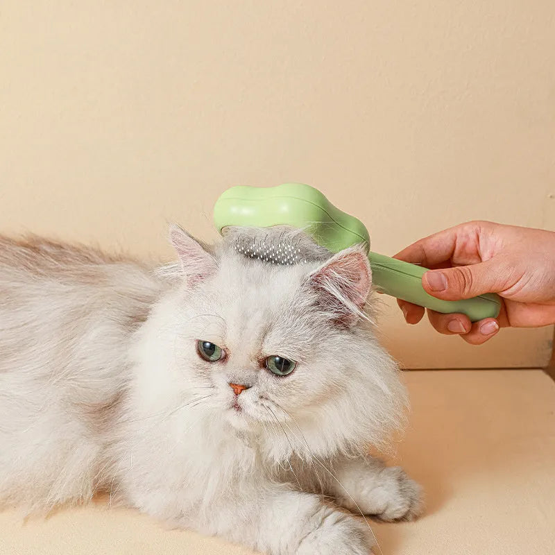 Green self-cleaning cat comb with stainless steel needles and retraction button