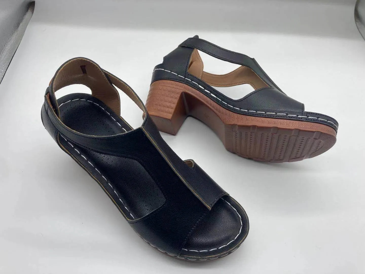 Women's white peep toe wedge sandals with a buckle strap on the ankle.