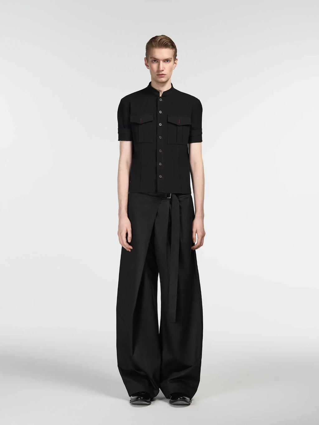 Black straight-leg Tencel cotton trousers with a single pleat and adjustable waistband on a hanger.
