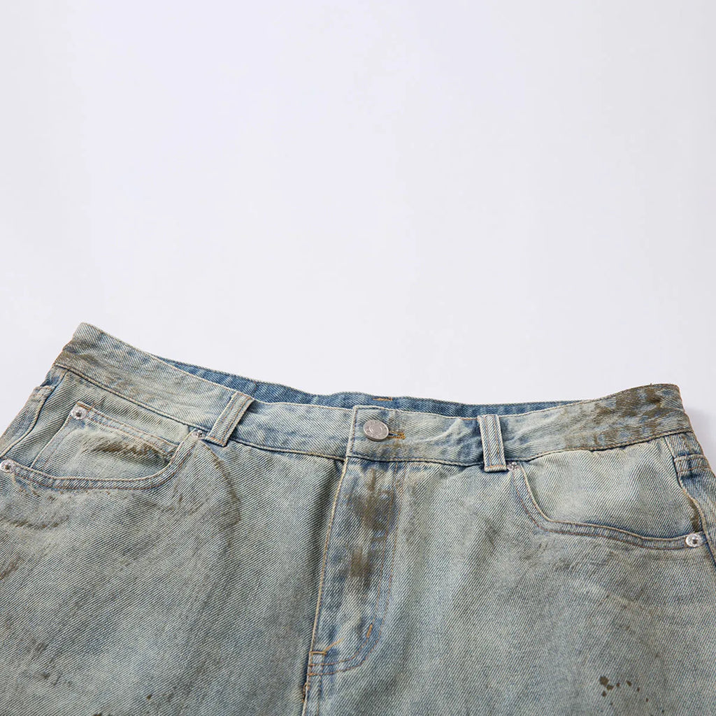 A pair of washed blue, cropped, straight-leg denim trousers on a plain background.