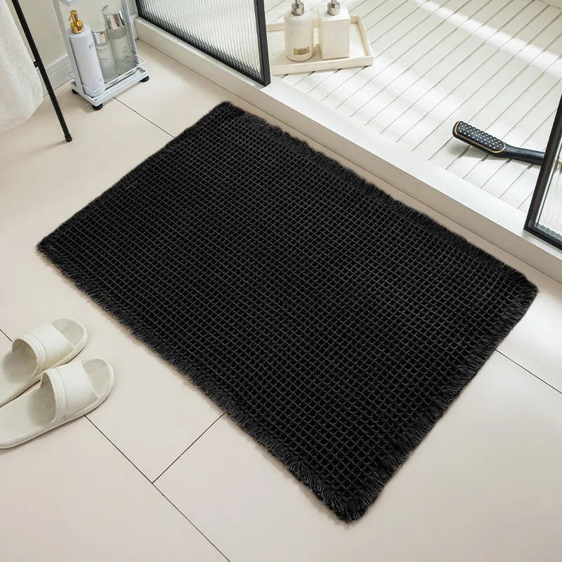 A square, checkered-pattern absorbent bathroom floor mat with a non-slip backing, shown in a neutral colour.