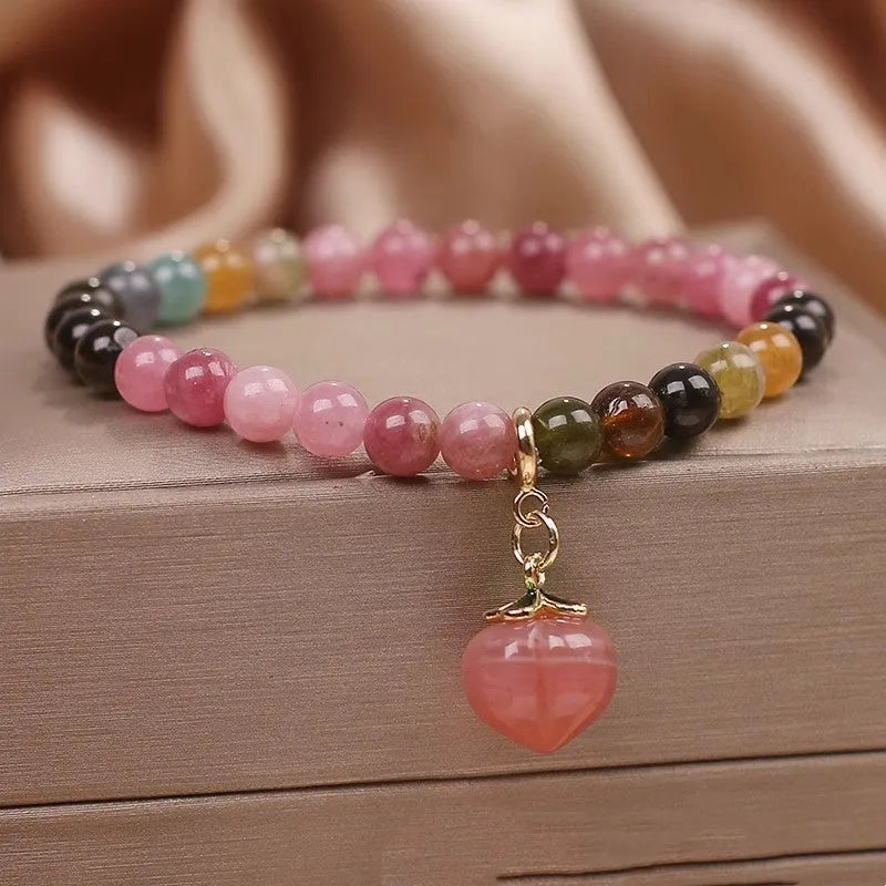 Natural rainbow tourmaline single-circle bracelet with agate peach pendant on wrist