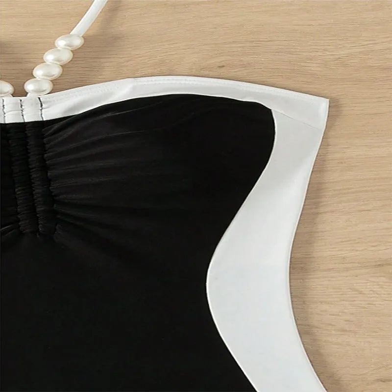 Black and white women's one-piece swimsuit with spaghetti straps and a slimming silhouette