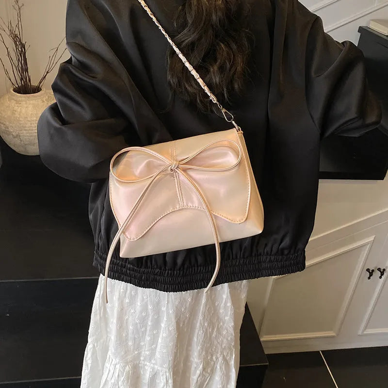 Women's black underarm bag in horizontal square shape showing sandwich pocket design and crossbody strap