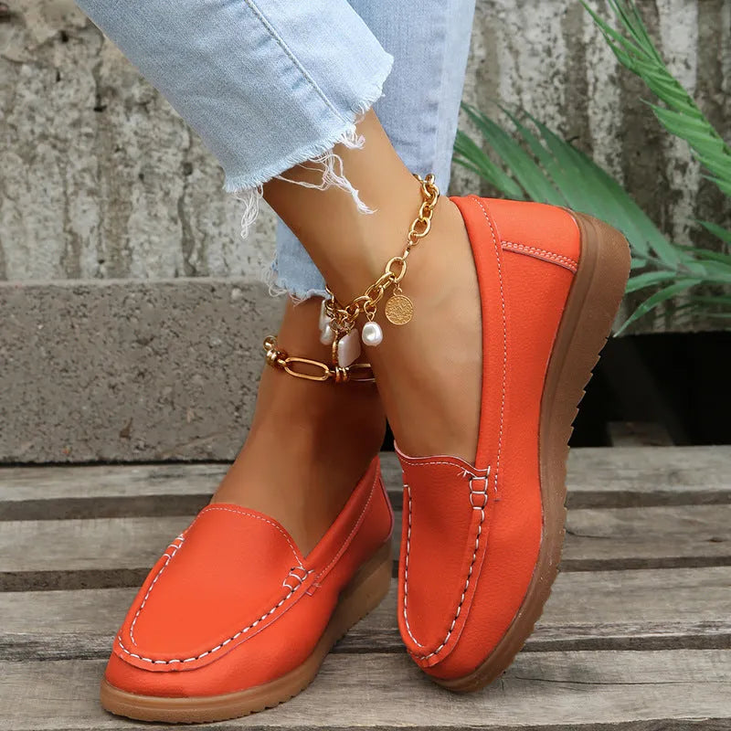 Women's flat slip-on loafers in PU leather with car suture detail, shown in multiple colours.