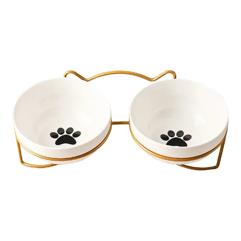 White ceramic pet bowl with cat footprints design in a black iron frame.