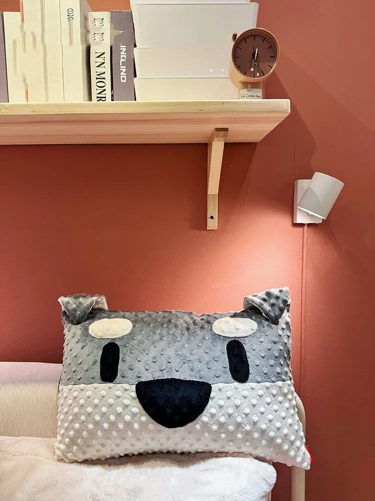Grey schnauzer and white West Highland puppy decorative cushion pillow on a sofa.