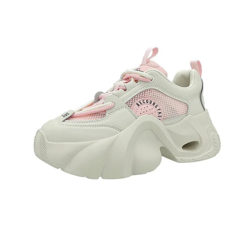 Women's pink casual sneakers with a cross strap, thick rubber sole, and mesh lining on a white background.