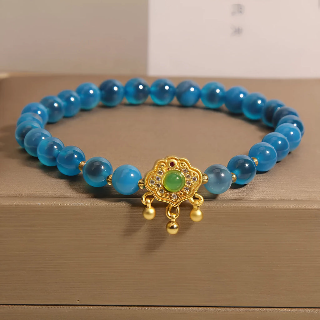 Blue sugar heart agate safety lock pendant on a crystal women's bracelet with alloy-set stones.
