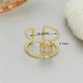 Gold-plated copper open ring with an asymmetric U-shape and adjustable opening.