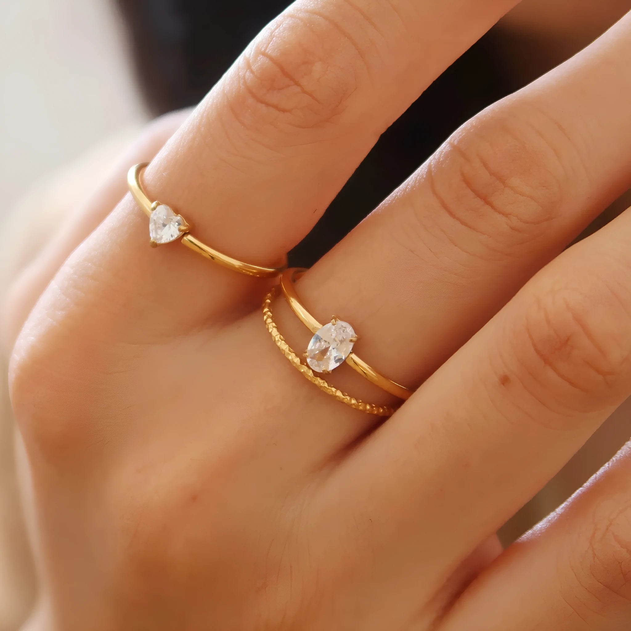 Golden stainless steel ring with heart shape or oval design on female hand