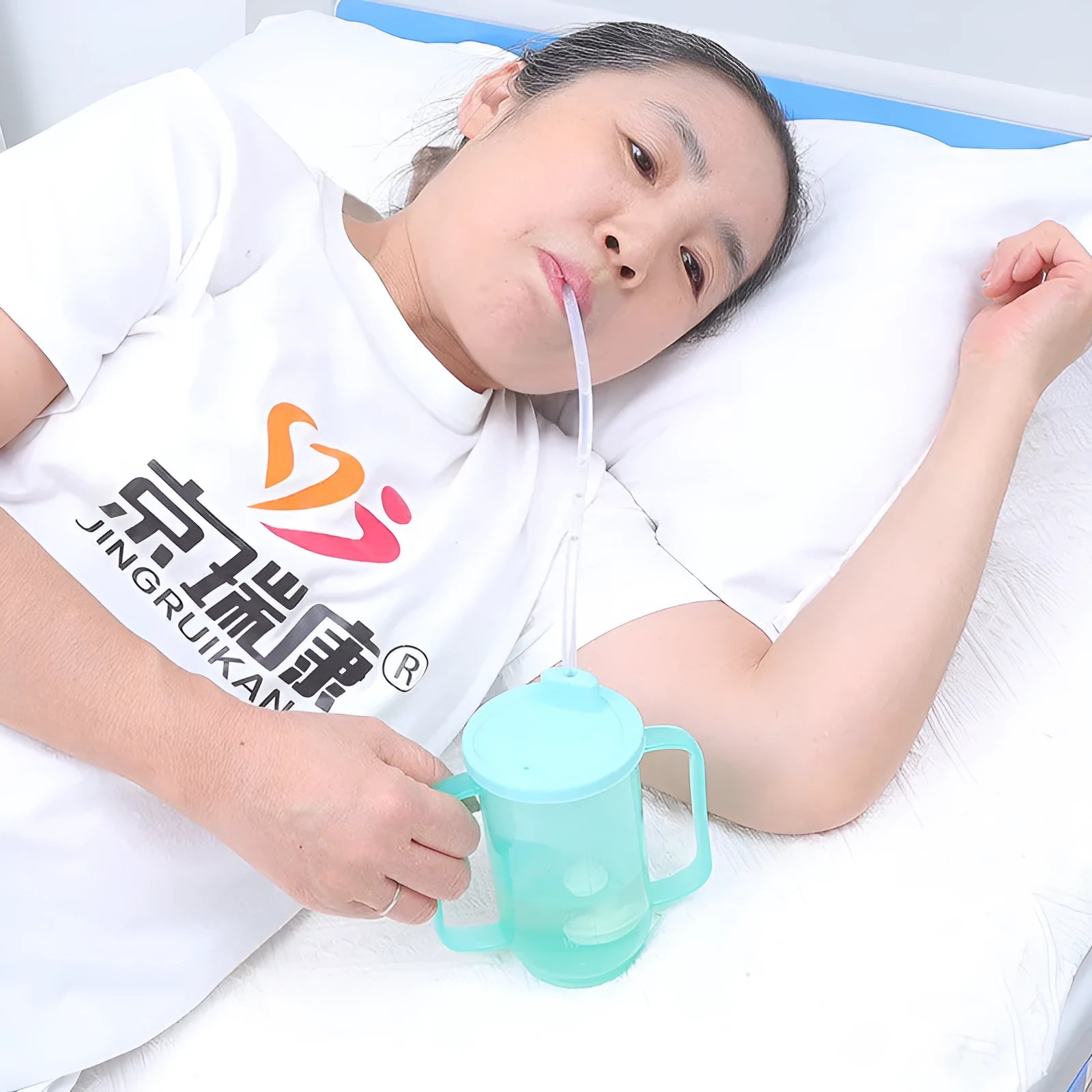 Oblique mouth choke-proof drinking cup with lid and handle, showing optional wrist splint attachment