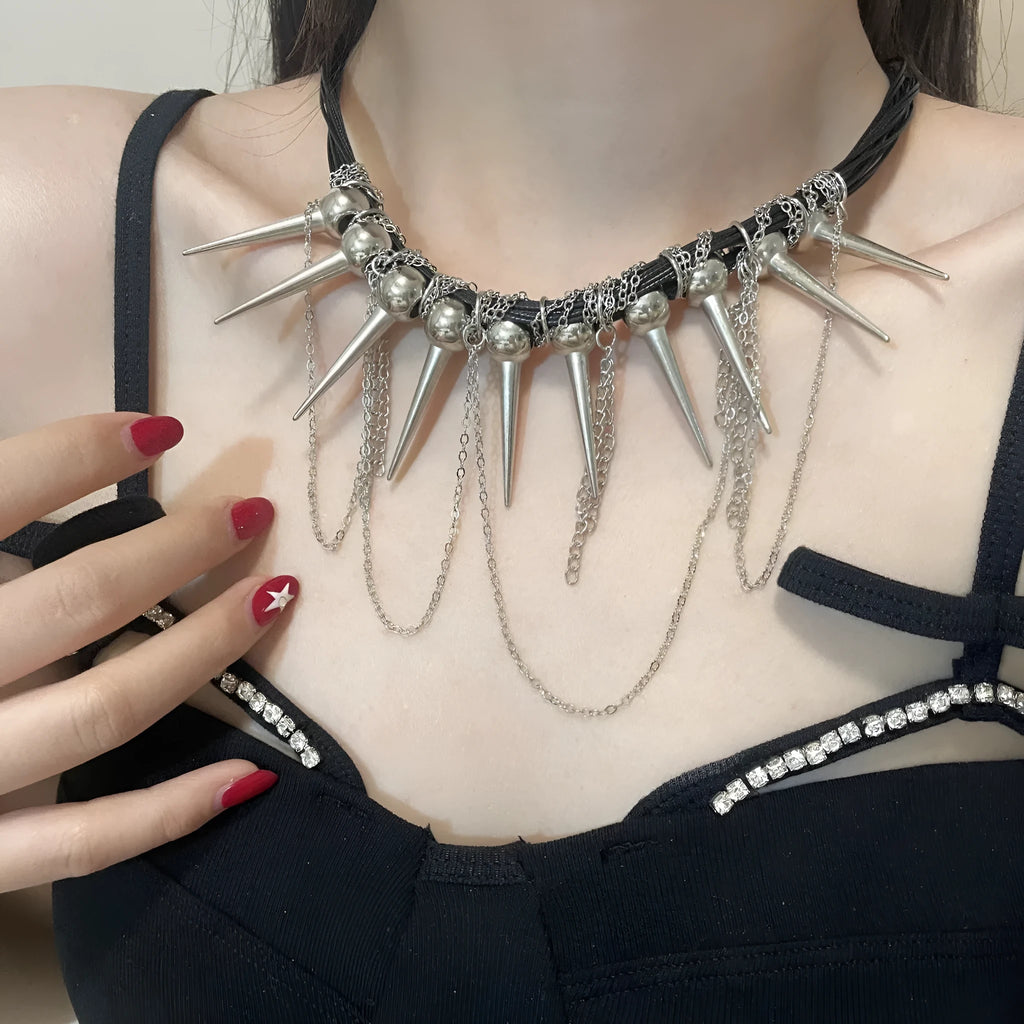 Leather necklace with round beads, a tassel, and silver rivet details on a white background.